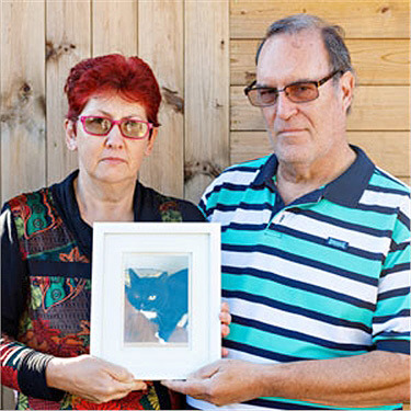 Couple holding a picture of a cat
