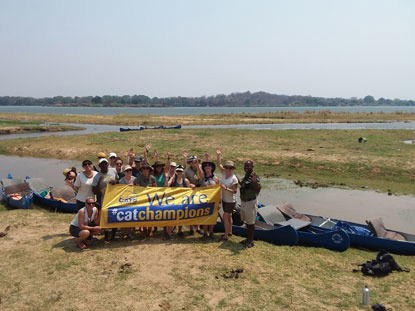 group of people next to  river holding a Cat Champions Cats Protection banner