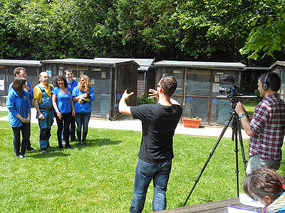 film crew directing Cats Protection staff and volunteers in garden