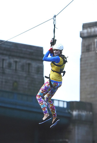 woman in Cats Protection vest attached to zip wire