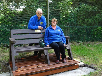 gardening volunteers by a bench in Cats Protection garden
