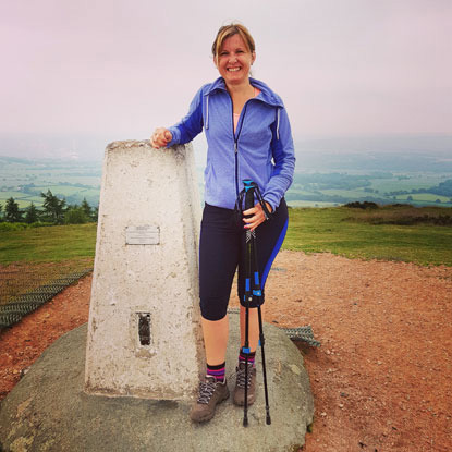 woman standing at the top of the Wrekin in Shopshire in trekking gear