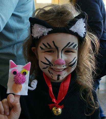 young girl with face painted as a cat