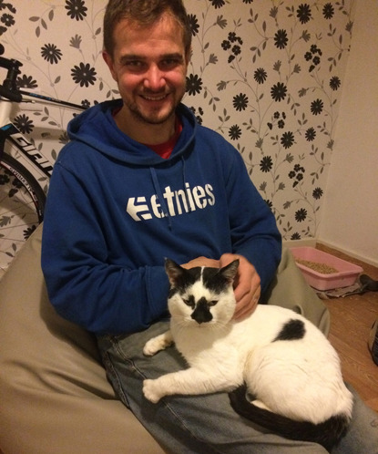 man sitting with white and black cat on his lap