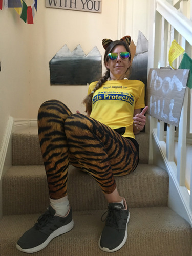 woman in Cats Protection t-shirt and fitness gear sitting on the stairs