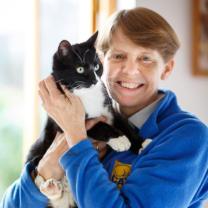woman in Cats Protection fleece holding black and white cat