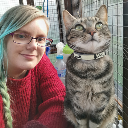 blonde woman next to tabby cat with collar