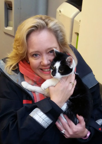 blonde lady hugging black and white cat