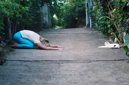 woman and cat doing yoga pose outside
