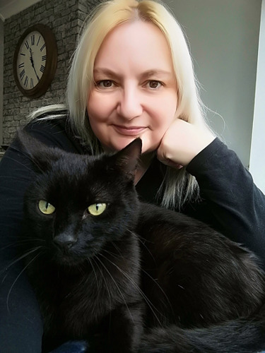 blonde woman with black cat on her lap
