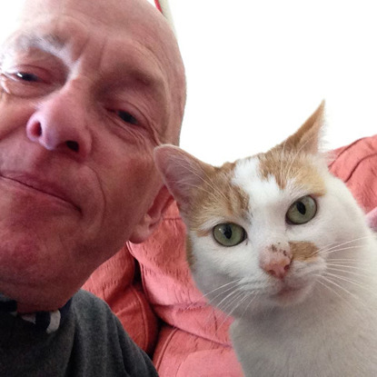 selfie of a man and his white and ginger cat