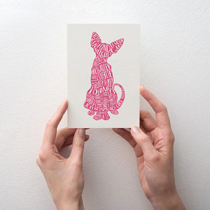 Hands holding a greetings card with a pink silhouette of a cat
