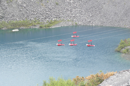 four people doing a zipwire challenge over a lake