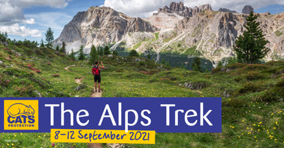 walker in front of Alps mountain range with 'The Alps Trek, 8-12 September 2021' wording